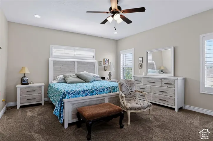Neutral-toned interior featuring recessed lighting, a multi-blade ceiling fan with integrated light fixture, and plantation shutters on dual windows