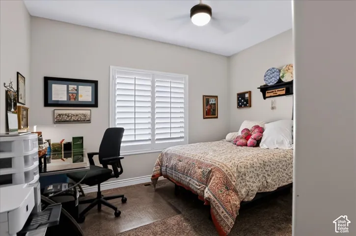 Room featuring white plantation shutters and a ceiling-mounted light fixture with a fan