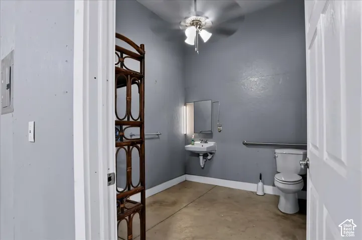 Wall-mounted sink, dual-handle faucet, attached medicine cabinet with integrated light, wall-mounted safety grab bar, and neutral-tone flooring