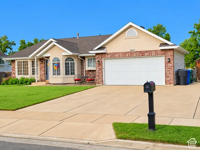 Stucco and brick exterior with a front-facing garage