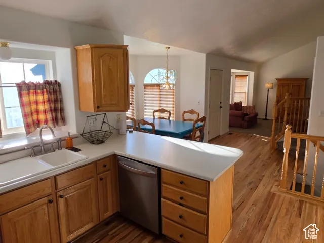 Kitchen with light wood-finish cabinetry, white countertops, and a double-basin sink