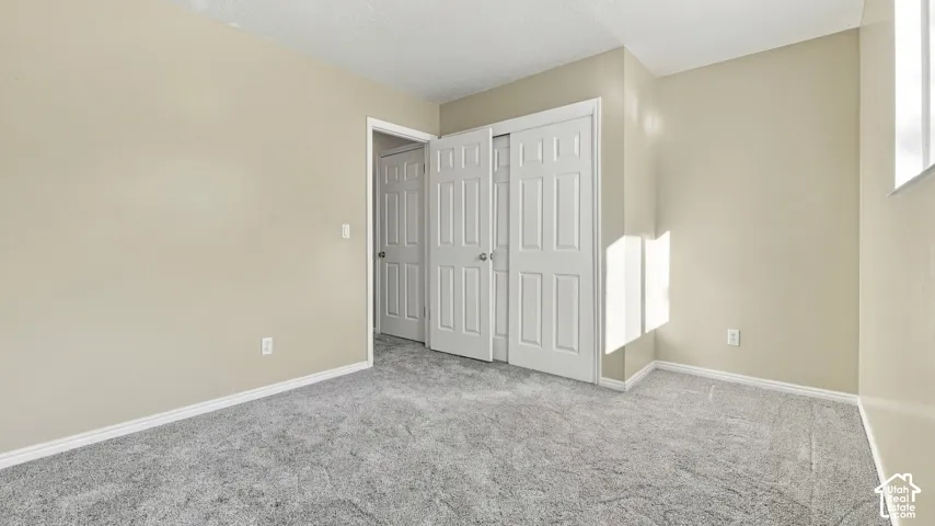 Neutral wall tones, gray carpeting, and white six-panel interior doors with brushed nickel hardware