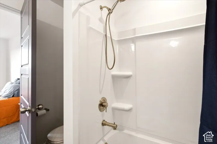 Shower and tub combination featuring a molded surround with integrated shelving and brushed nickel fixtures