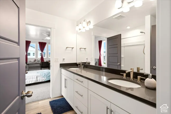Dual-sink vanity with quartz countertop, under-mount basins, brushed metallic fixtures, and full-width mirror