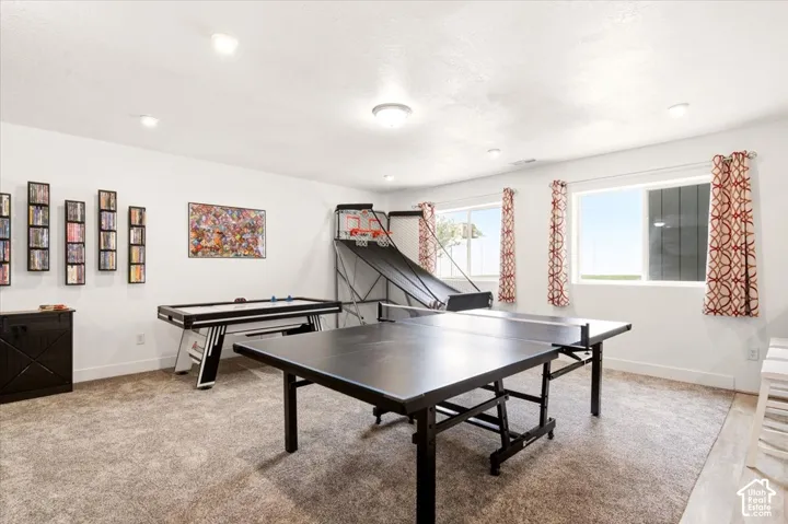 Neutral-toned interior space featuring recessed ceiling lighting, wall-to-wall carpeting, and sliding windows
