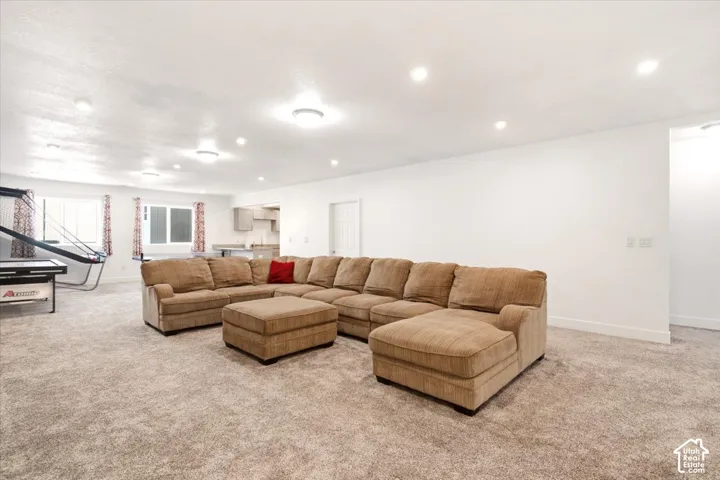 Expansive interior space featuring neutral wall-to-wall carpeting, recessed ceiling lighting, and multiple windows