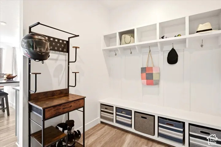 Built-in white storage bench with integrated open cubbies, vertical wall paneling, and brushed nickel hardware
