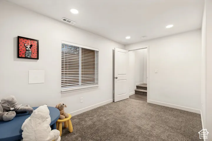 Room featuring recessed lighting, wall-to-wall carpeting, and a single-hung window with horizontal blinds