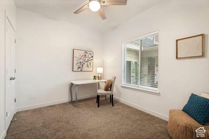 Room with neutral carpet flooring, ceiling fan with integrated lighting, window with horizontal blinds, and paneled closet door