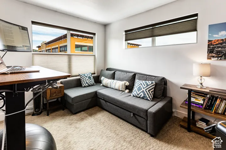 Neutral interior space featuring carpeting and windows equipped with fitted pleated blinds