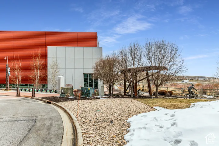 Exterior featuring corrugated metal siding, smooth panel cladding, and a decorative structural steel pergola