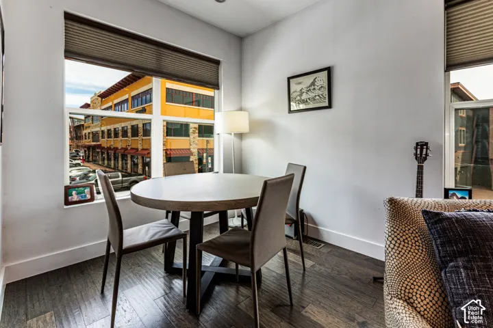 Dark wood-finish flooring, dual oversized windows, and retractable cellular shades