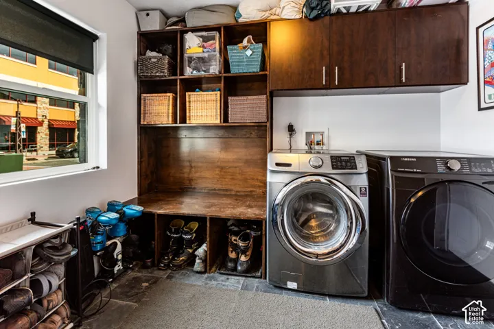 Custom built-in wood cabinetry, integrated storage cubbies, overhead storage units, and stone flooring