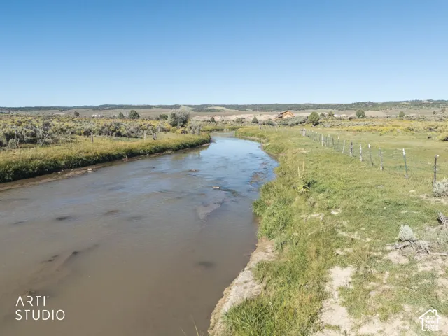 Natural creek frontage featuring native grasses, open terrain, and mountain backdrop