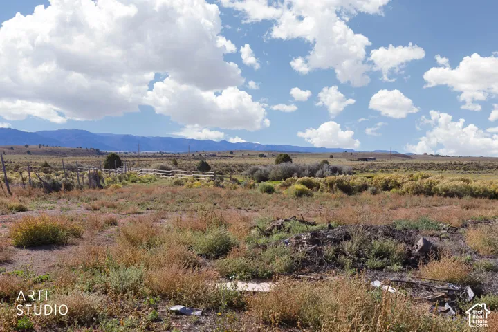 Expansive open lot featuring natural high-desert landscape and mountain range horizon