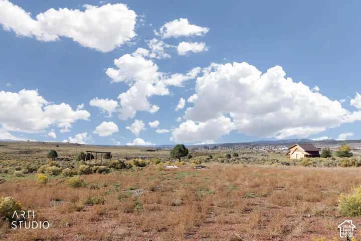 Expansive acreage featuring native high-desert vegetation, a freestanding timber-frame pergola, and prominent mountain backdrop