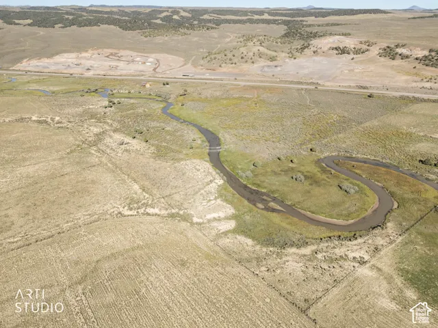 Expansive acreage featuring a meandering creek, native grasses, and hilly terrain