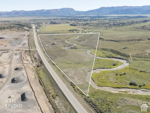 Expansive acreage featuring a winding creek, native grasses, and mountainous topography