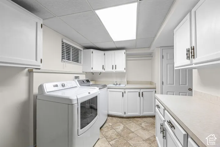 Laundry room featuring white cabinetry, built-in utility sink, stone-finish countertops, tiled flooring, and recessed ceiling lighting