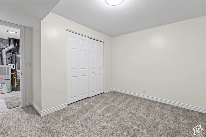 Neutral-toned carpeting, white six-panel sliding closet doors, and flush-mount overhead lighting