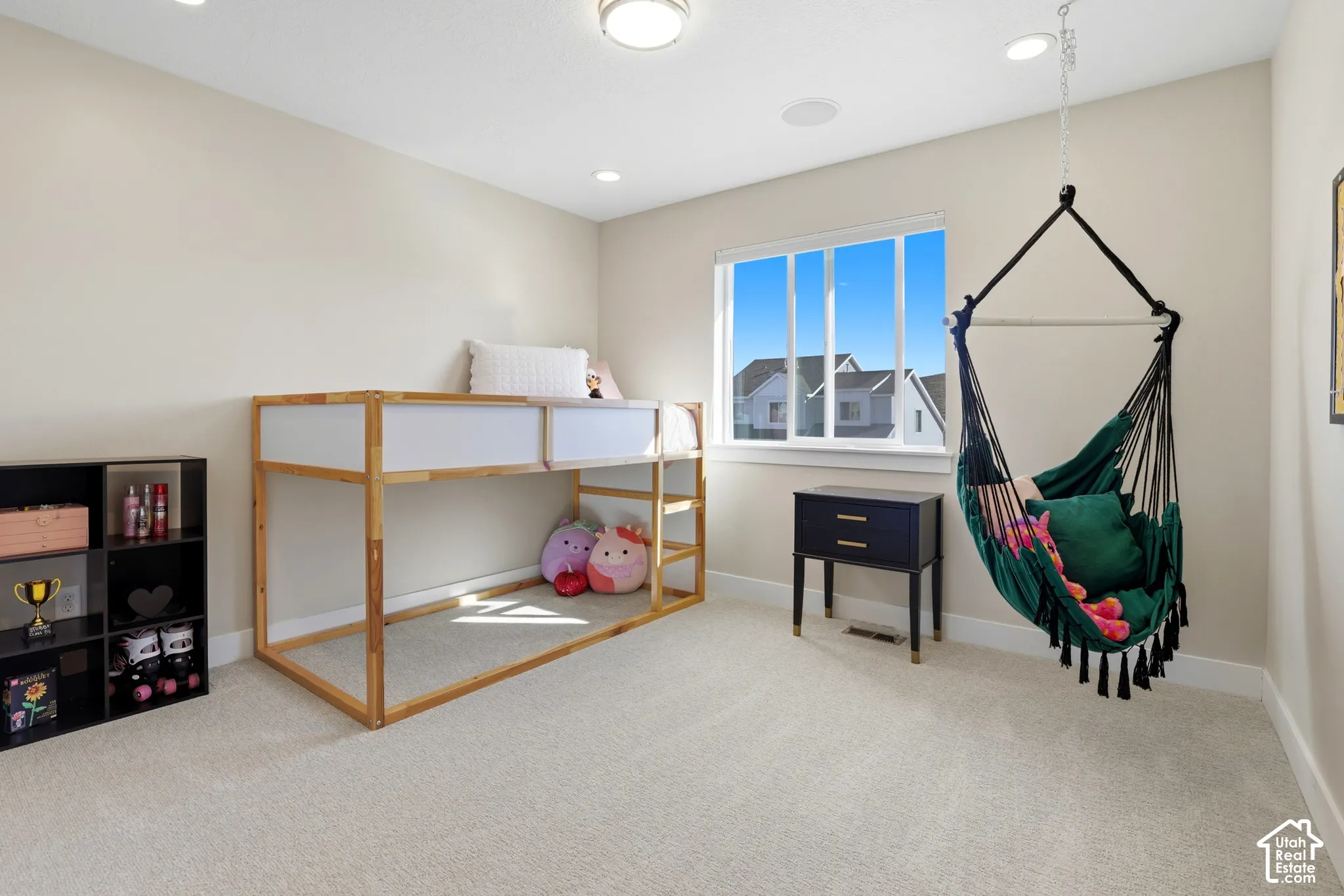 Neutral-toned interior featuring recessed lighting, plush carpeting, and a single-pane window with a white frame