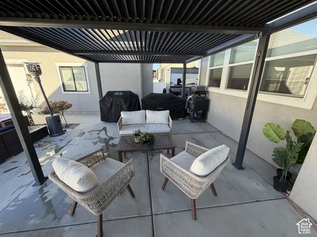 Covered patio featuring an adjustable louvered roof system, concrete slab foundation, and stucco exterior walls