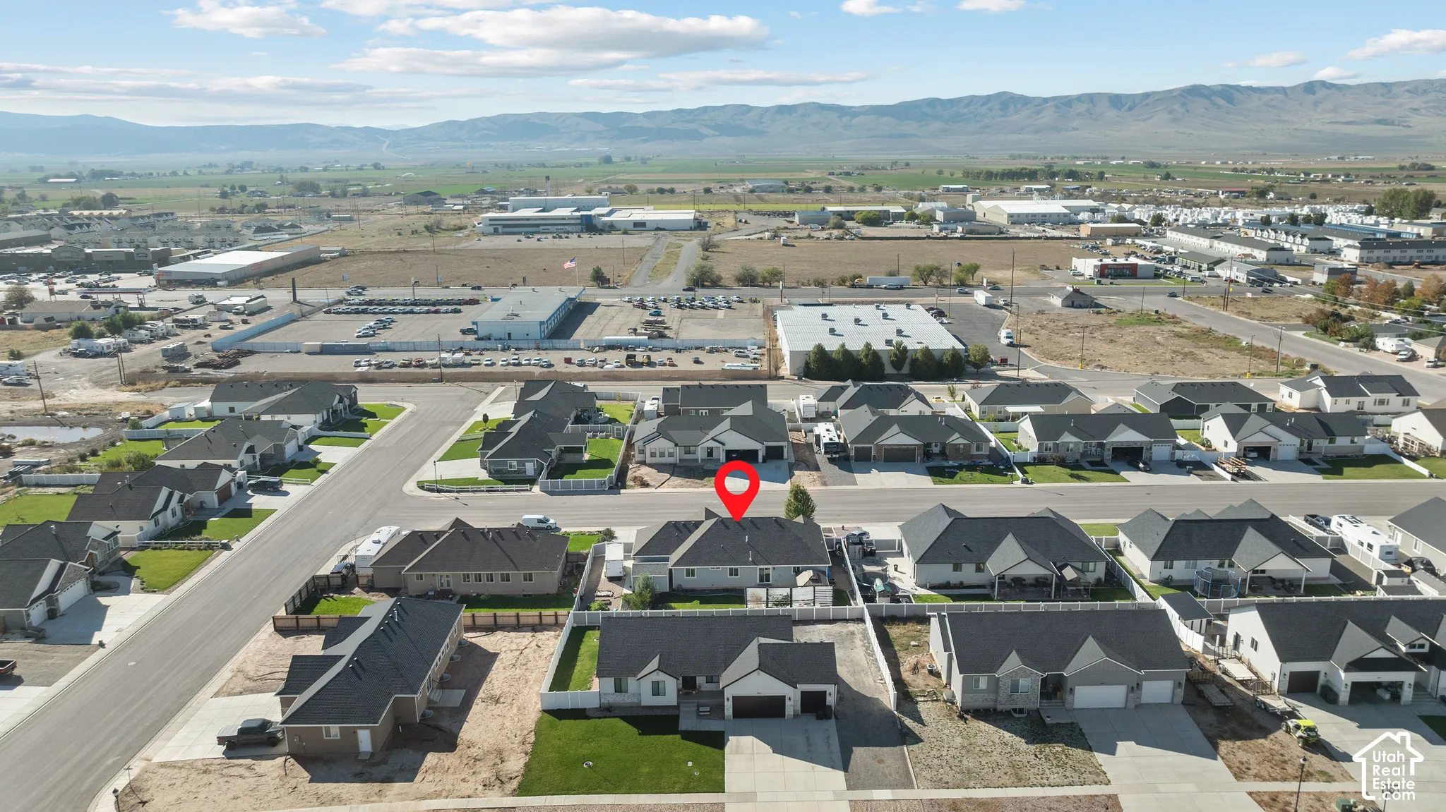 Aerial perspective of a single-story residence featuring a multi-gabled roofline, an attached two-car garage, and mountain-range backdrops