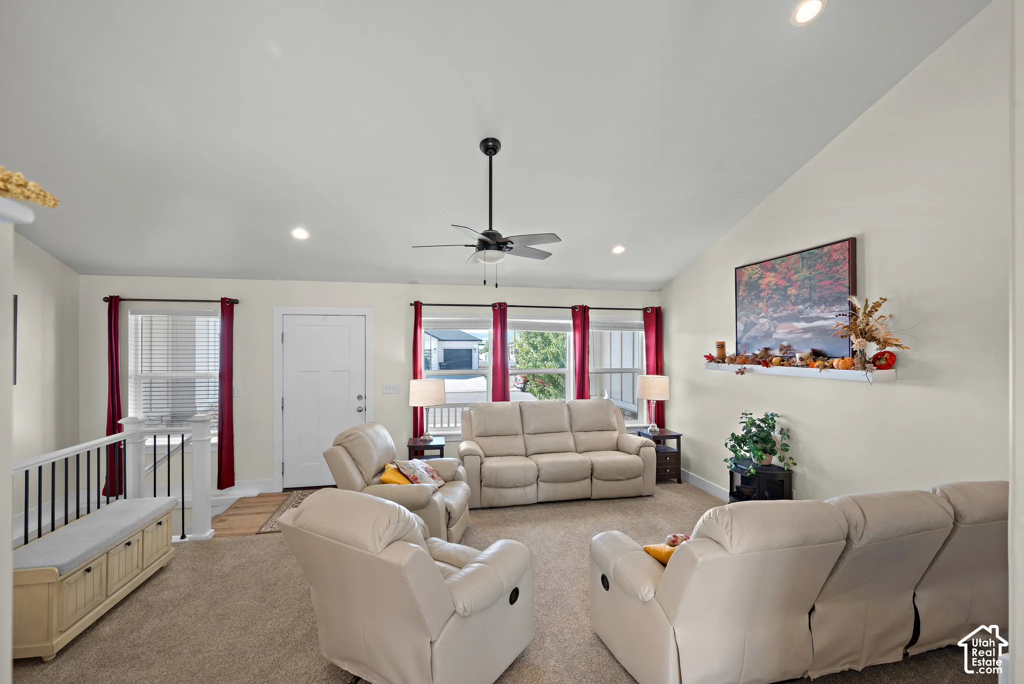 Vaulted ceilings featuring recessed lighting, a ceiling fan, multiple windows with neutral-toned trim, and a wall-mounted display shelf