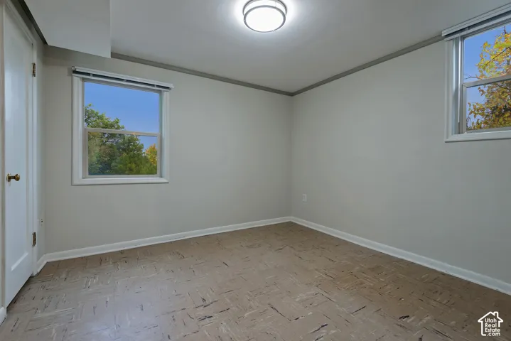Interior room featuring neutral wall paint, two windows with blinds, patterned flooring, and a central flush-mount ceiling light
