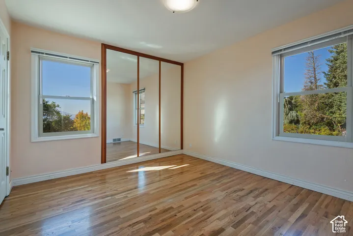 Hardwood flooring, triple-panel mirrored closet doors, and dual double-pane windows