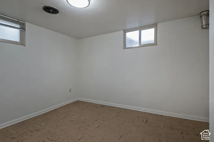 Interior room featuring neutral wall paint, tile flooring, and dual sliding windows with horizontal blinds