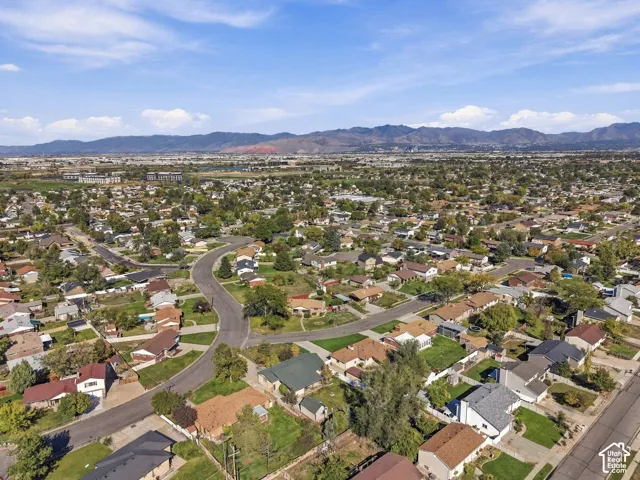 Aerial perspective featuring residential lots with mature trees and a prominent mountain range backdrop