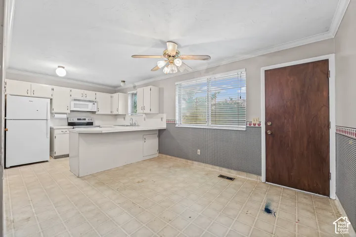 Kitchen featuring a breakfast bar, dining, white cabinetry, integrated appliances, horizontal window blinds, and a ceiling fan