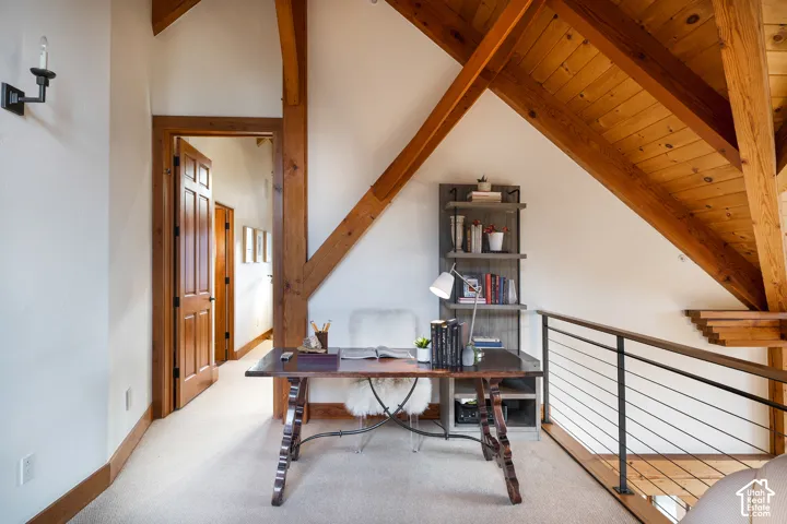 Exposed timber beam ceiling, metal-railed staircase, solid wood-core doors, and wall-mounted sconce lighting