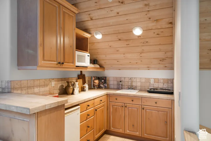 Kitchenette featuring wood cabinetry, tiled countertops, a drop-in sink, natural wood-paneled ceiling, and recessed lighting