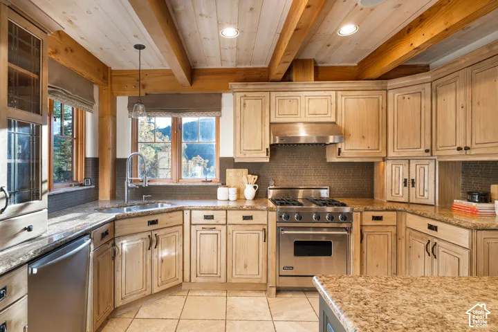 Kitchen featuring rustic natural wood cabinetry, exposed timber ceiling beams, stone-finish countertops, stainless steel professional-grade range, and tile flooring
