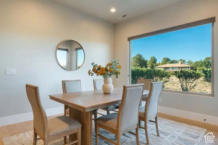 Interior space featuring high ceilings, recessed lighting, wood-finish flooring, and a large picture window