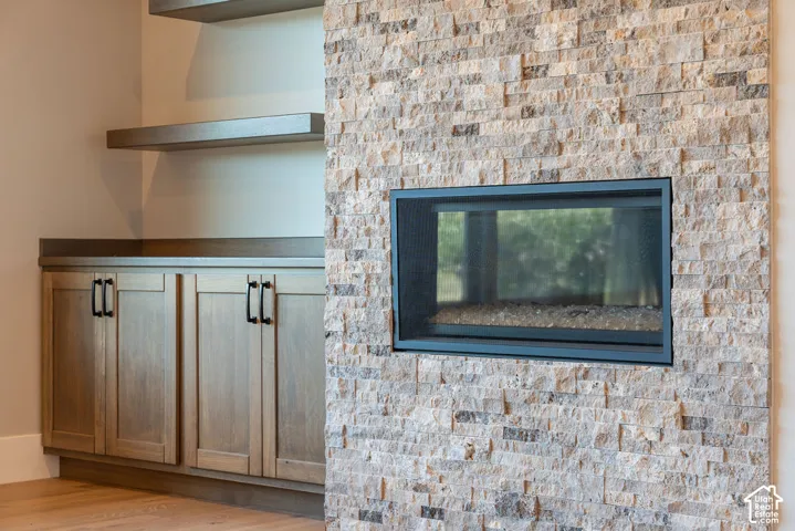 Recessed fireplace with a tile surround, built-in cabinetry, and floating shelves
