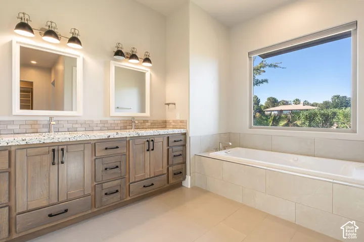 Dual vanity with wood-finish cabinetry, stone countertops, and rectangular mirrors