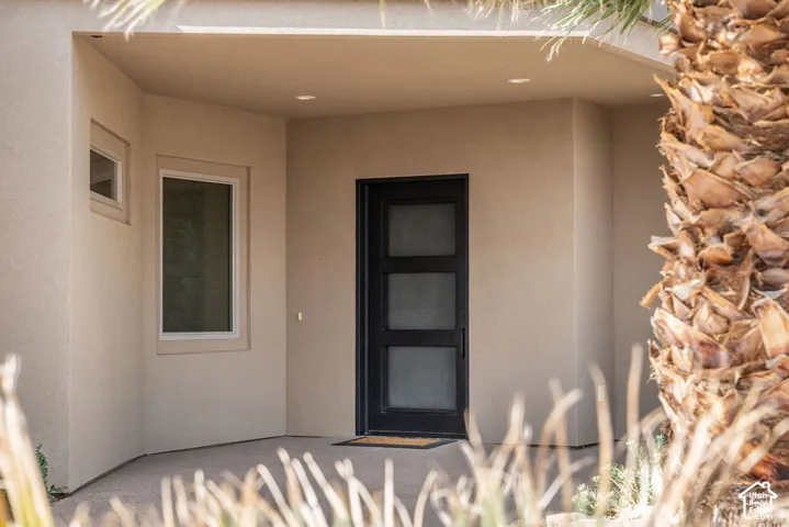 Covered entry featuring a black-framed glass door with multiple panes, complemented by a transom window and recessed ceiling lighting