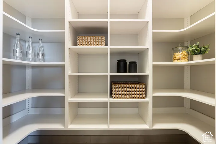 Custom white built-in shelving with adjustable height tracks and tiered corner storage