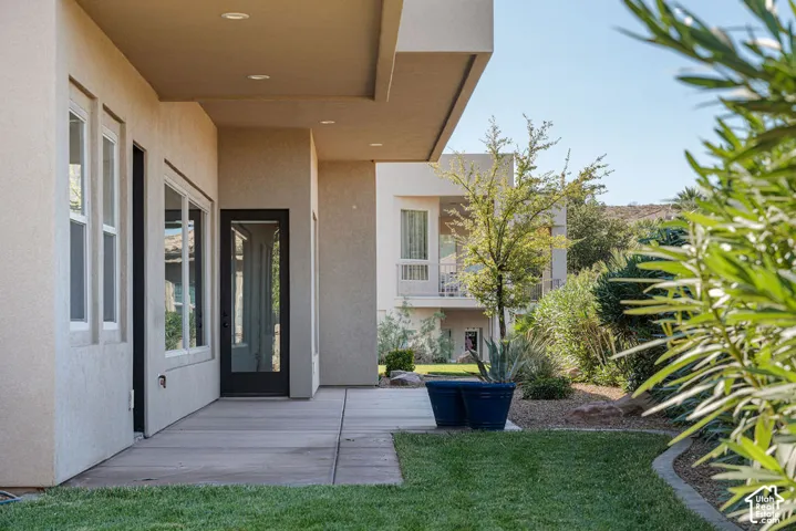 Exterior patio with concrete flooring, recessed lighting, and a glass-paneled door