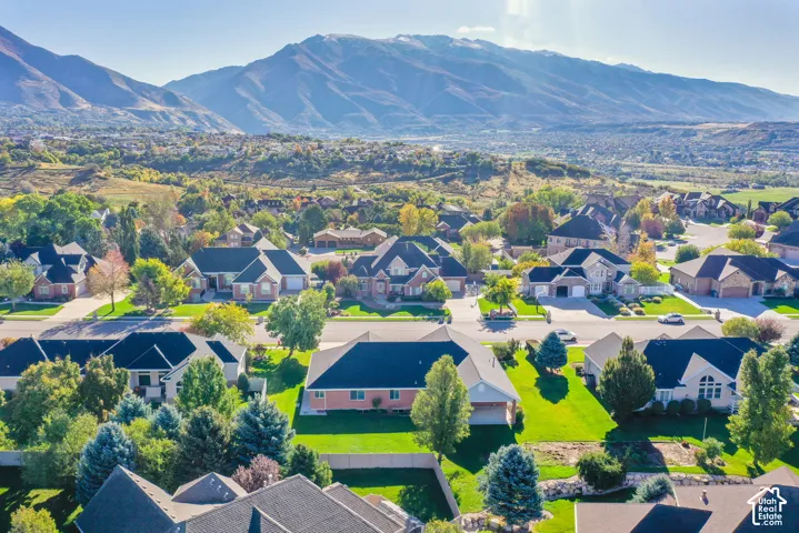 Aerial perspective of residential neighborhood featuring expansive mountain backdrop and mature landscaping