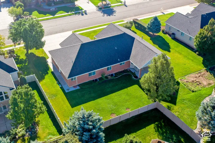 Brick exterior, asphalt shingle roof, concrete driveway, and fenced-in backyard with mature trees