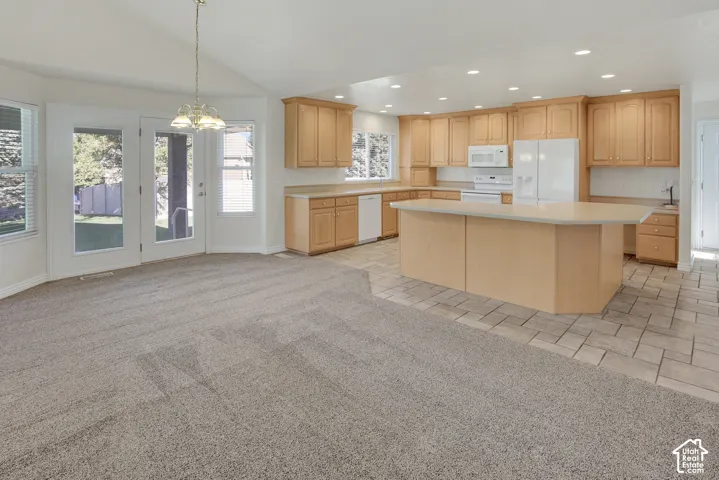 Kitchen featuring light wood cabinetry, a central island with a countertop, recessed ceiling lighting, tile flooring, and glass-paneled double doors