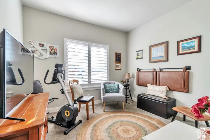 Room featuring neutral-toned walls, carpeting, and plantation shutters