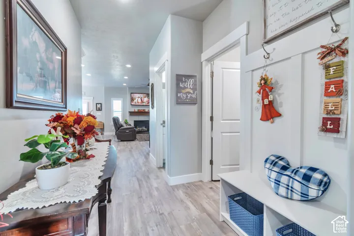 Entryway featuring wood-finish flooring, built-in white hall tree with storage bench, recessed lighting, and crisp white trim
