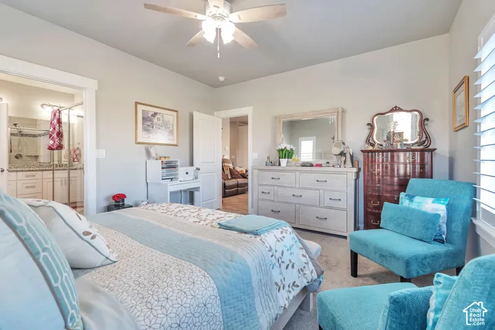 Room featuring high ceilings, a ceiling fan with light fixture, neutral wall paint, and white shutter window treatments