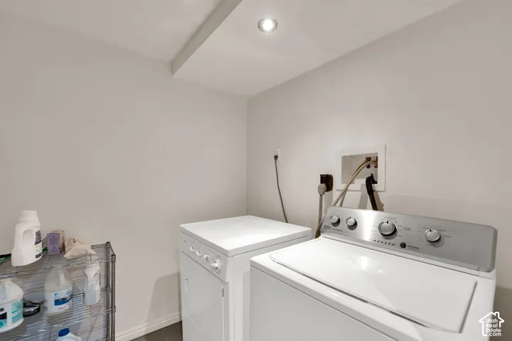 Dedicated utility space featuring recessed ceiling lighting and recessed wall plumbing connections