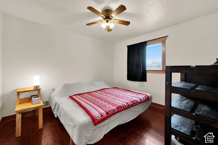 Wood-finish flooring, ceiling fan with integrated lighting, and natural wood window casing